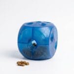 Miękka, kostka interaktywna BUSTER Soft Cube marki Kruuse w jaskrawym kolorze, z otworami na przysmaki, przeznaczona dla psów i kotów.